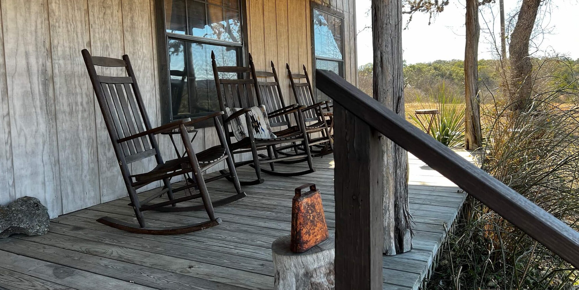 Empty rocking chairs sit abreast on the front porch of the lodge